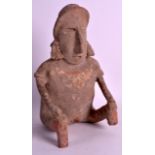 A PRE COLUMBIAN POTTERY FIGURE OF A MALE modelled holding both knees. 10.5ins high.