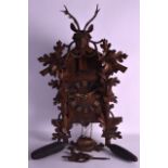 AN EARLY 20TH CENTURY BLACK FOREST BAVARIAN WALL CUCKOO CLOCK carved with a stag, a pair of hounds &