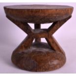 AN EARLY 20TH CENTURY CARVED AFRICAN TRIBAL STOOL with circular top, thick carved supports. 9Ins x