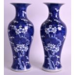 A PAIR OF EARLY 20TH CENTURY CHINESE BLUE AND WHITE VASES painted with prunus. 10.5ins high.