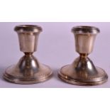 A SMALL PAIR OF ENGLISH HALLMARKED SILVER DWARF CANDLESTICKS. 3.25ins high.