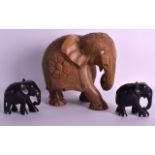 AN EARLY 20TH CENTURY AFRICAN CARVED WOOD FIGURE OF AN ELEPHANT together with two carved ebony