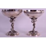 A MATCHED PAIR OF 1930S SPANISH SILVER TAZZAS each modelled as a semi clad female holding aloft