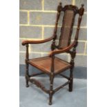 A 17TH CENTURY STYLE CARVED OAK CARVER ARMCHAIR with ticker seat and carved backsplat.