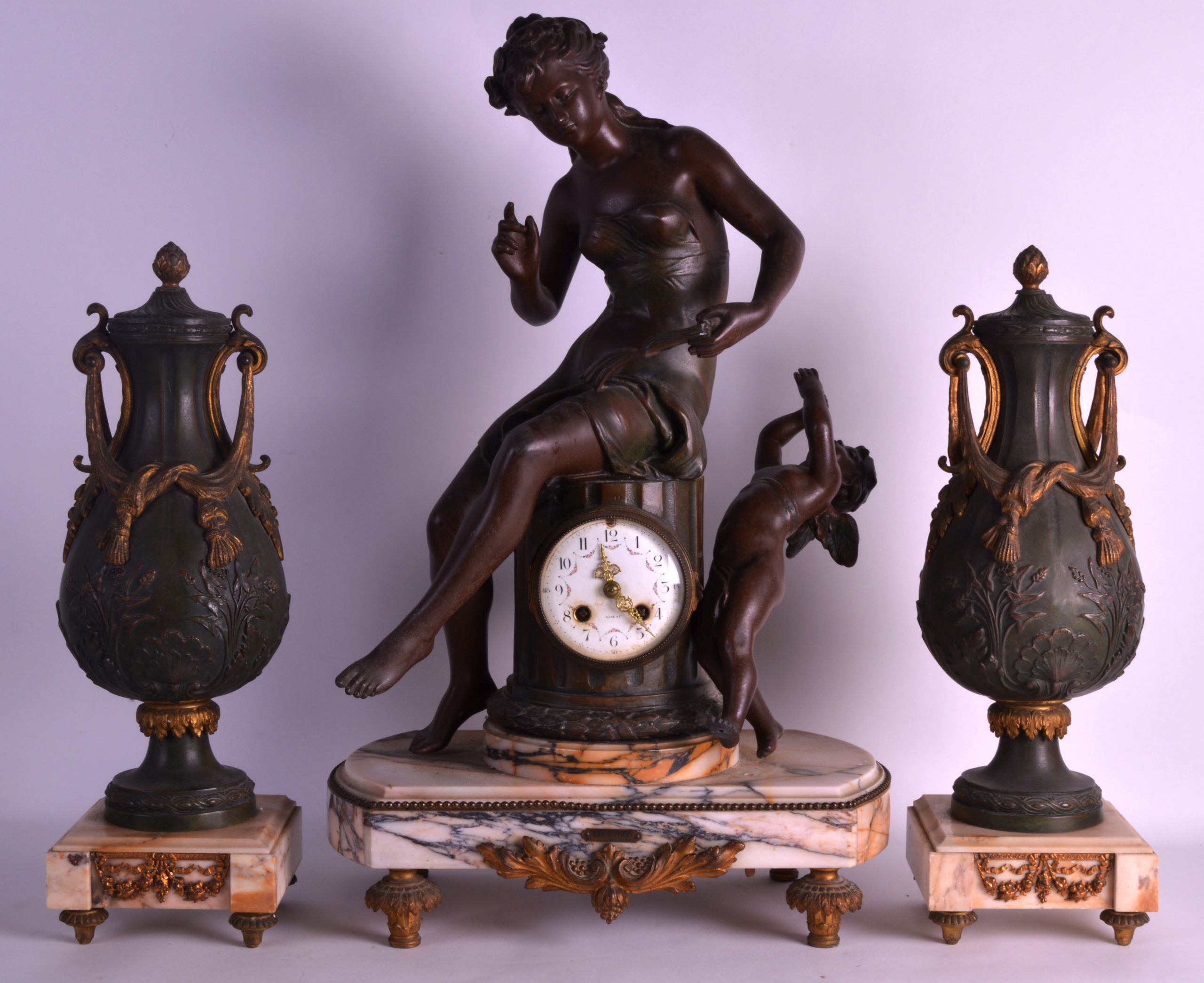 A LARGE EARLY 20TH CENTURY SPELTER CLOCK GARNITURE modelled as a female beside a winged cupid, the