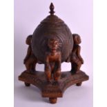 A LATE 19TH CENTURY CARVED AFRICAN COCONUT SHELL ON STAND with figural supports, carved with