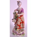 AN 18TH CENTURY DERBY PATCH MARK FIGURE OF A YOUNG LADY modelled selling flowers with pink bodice