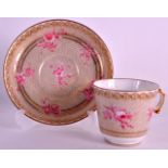 A LATE 19TH CENTURY SEVRES PORCELAIN TEACUP AND SAUCER painted with pink flowers upon a gilt