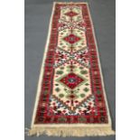 AN INDIAN MIRZAPUR LONG WHITE GROUND RUNNER decorated with motifs. 12Ft x 2ft 8ins.