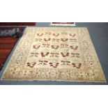 A 20TH CENTURY ZIEGLER RUG with soft beige tones, set with a deep red all over stylised motifs.