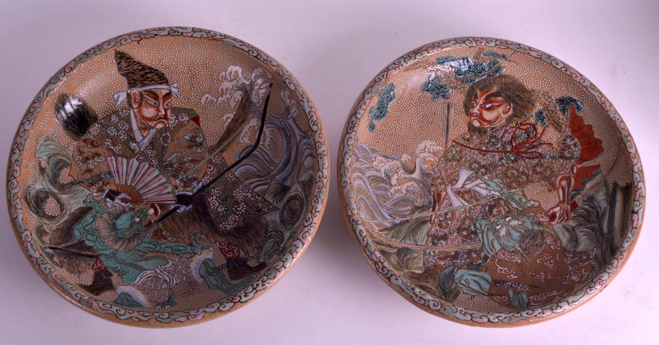 A PAIR OF LATE 19TH CENTURY JAPANESE MEIJI PERIOD SATSUMA CHARGERS decorated with figures and beasts