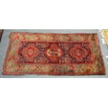 A LATE 19TH/20TH CENTURY CAUCASIAN SHIRVAN RUG decorated upon a red ground. 5Ft x 2ft 8ins.
