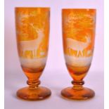 A PAIR OF BOHEMIAN SMOKEY AMBER GLASS VASES incised with a stag and fawn within a landscape. 7.75ins