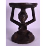 AN EARLY 20TH CENTURY CARVED AFRICAN TRIBAL STOOL modelled as a seated female with elongated arms.