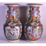A PAIR OF 19TH CENTURY CHINESE CANTON FAMILLE ROSE VASES painted with figures within interiors,