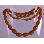 AN EARLY 20TH CENTURY AMBER TYPE BEAD NECKLACE of graduated form. Largest bead 0.75ins wide, overall