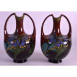 A PAIR OF ART NOUVEAU ARNHEIM POTTERY VASES painted with foliage and vines. 7.75ins high.