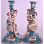 A PAIR OF 19TH CENTURY MINTON PORCELAIN FIGURAL CANDLESTICKS decorated upon a blue ground. 12.