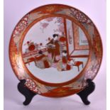 A 19TH CENTURY JAPANESE KUTANI PORCELAIN DISH painted with three geishas within an interior. 11.5ins