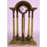 AN EARLY 20TH CENTURY FRENCH ONYX MANTEL CLOCK with arched top and circular dial, supported by