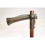 A SOUTH AFRICAN TRIBAL AXE, 19th century, the shaped iron axe head joined to a hard wood shaft via