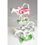 TWO SIMILAR STAFFORDSHIRE POTTERY COW CREAMERS AND COVERS, early 19th century, one with black