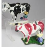 TWO POTTERY COW CREAMERS, early 19th century, one with black and white markings and cover, with a