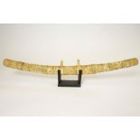A JAPANESE CARVED MARINE IVORY MOUNTED WAKIZASHI, with curved single edged blade, the grip and