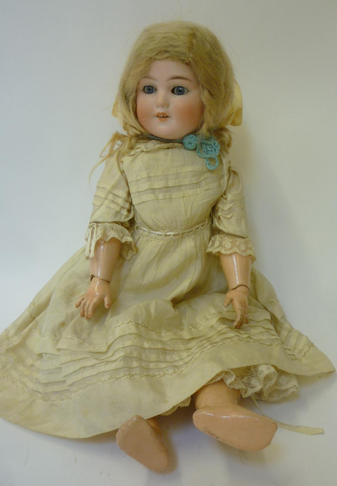 A Schoenau & Hoffmeister bisque head girl doll with blue glass sleeping eyes, open mouth and