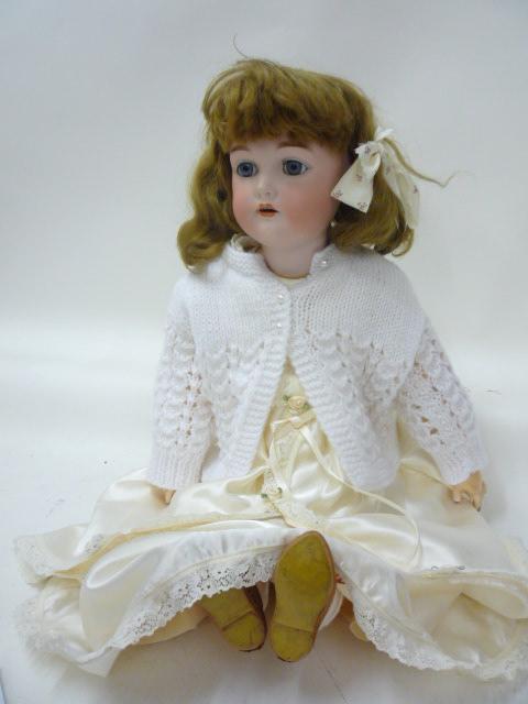 A Kammer & Reinhardt bisque head girl doll with blue glass sleeping eyes, open mouth and teeth,