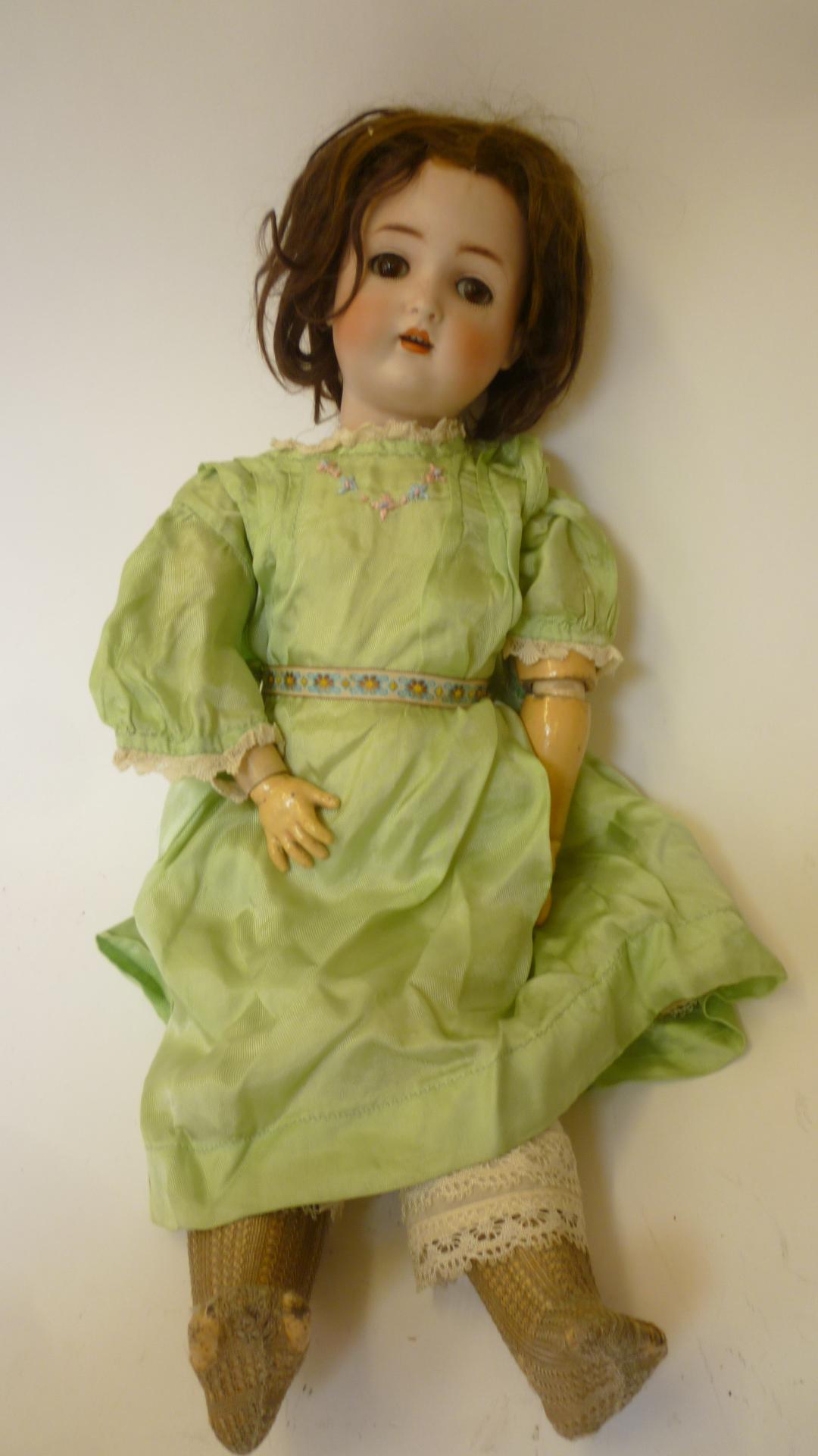 A Kestner bisque head girl doll with brown glass sleeping eyes, open mouth and teeth, brown mohair