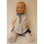 An Armand Marseille bisque head baby doll with blue glass sleeping eyes, open mouth and teeth,