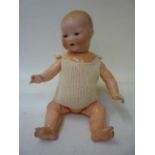 An Armand Marseille bisque head baby doll with blue glass sleeping eyes, open mouth and teeth,