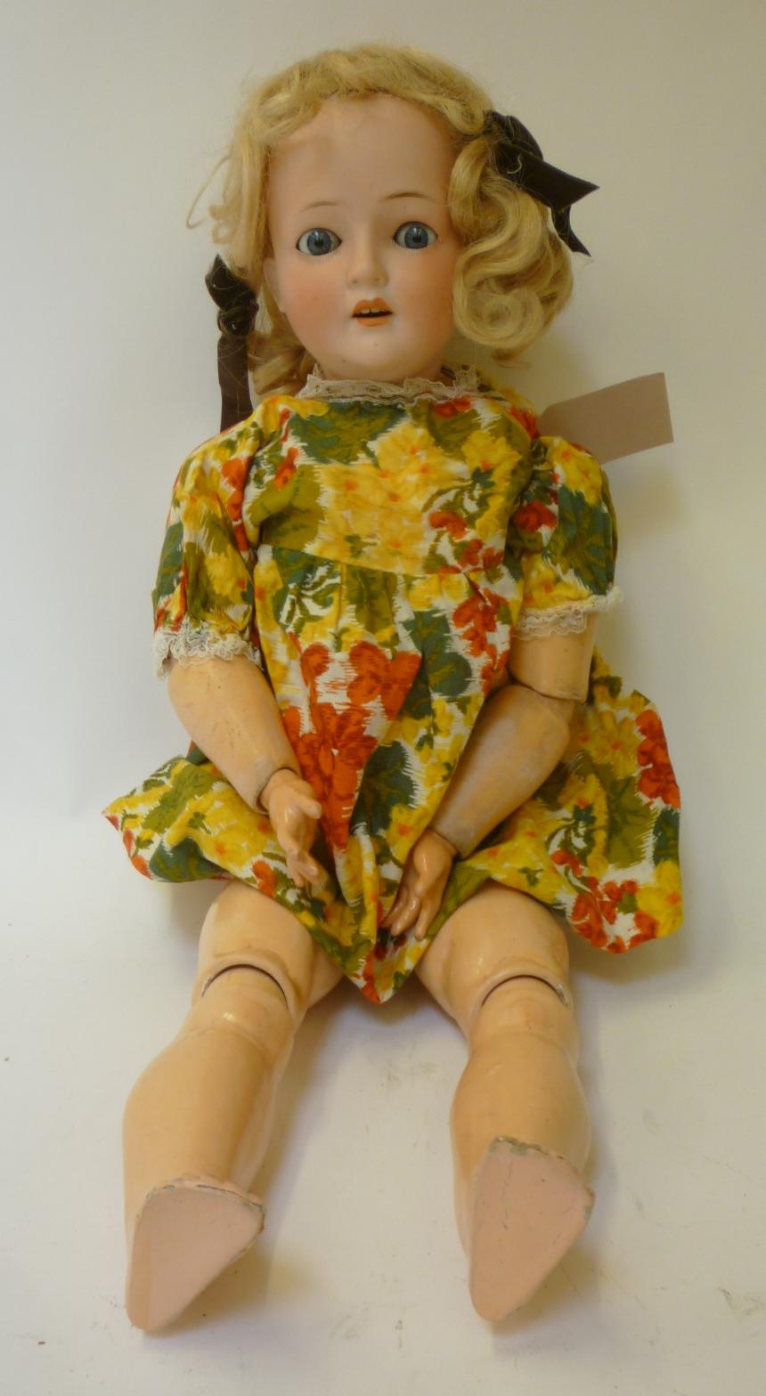 A German bisque "Revalo" type doll with blue glass sleeping eyes, open mouth and teeth, blonde