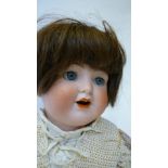 A Kammer & Rheinhardt bisque head character doll with blue glass sleeping eyes, open mouth and