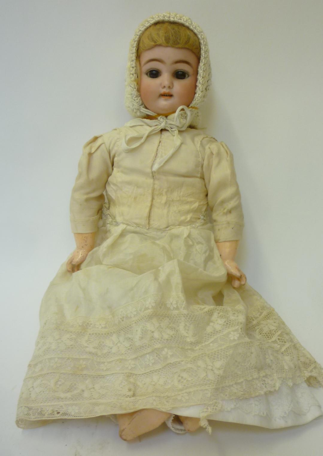 A Simon & Halbig bisque head girl doll with brown glass sleeping eyes, open mouth and teeth, pierced