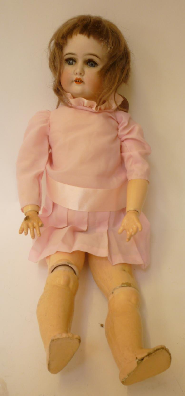 A Gebruder Kuhnlenz bisque head girl doll with blue glass sleeping eyes, open mouth and teeth, brown