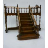 A single flight miniature staircase in mahogany extended landing with turned balustrade matching
