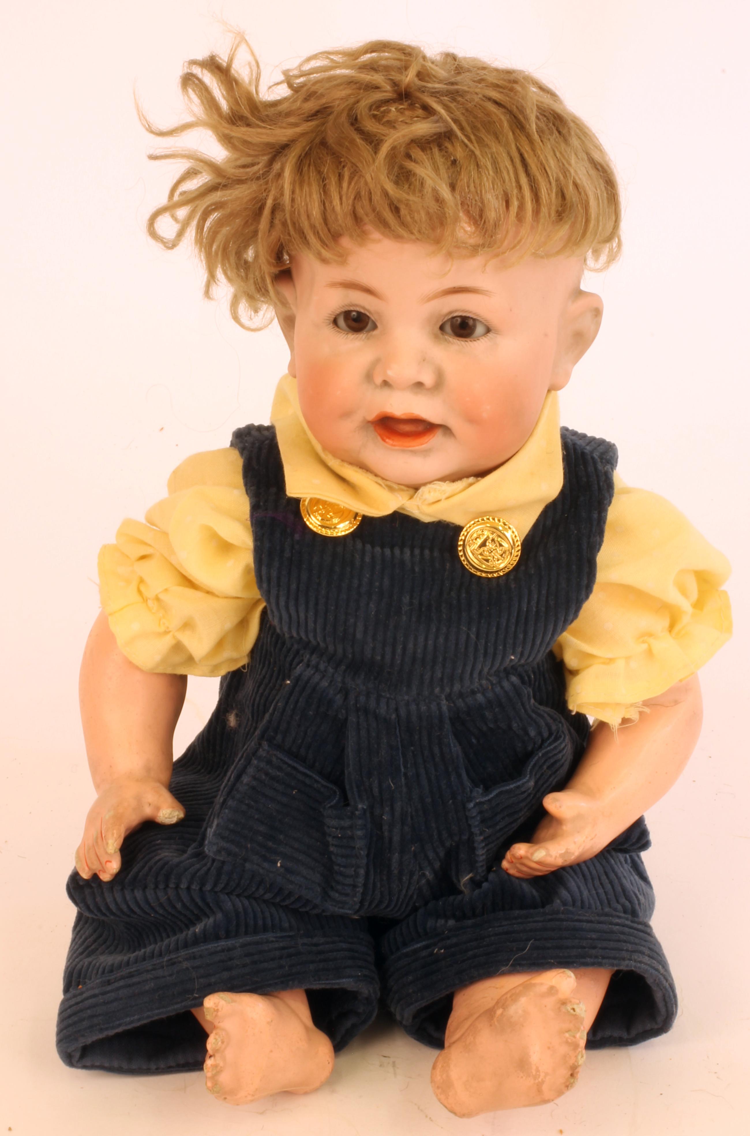 A Kammer & Reinhardt bisque head character boy doll with brown glass sleeping eyes, open mouth,