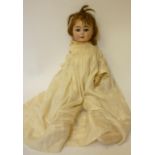 An Armand Marseille bisque head girl doll with brown glass sleeping eyes, open mouth and teeth,