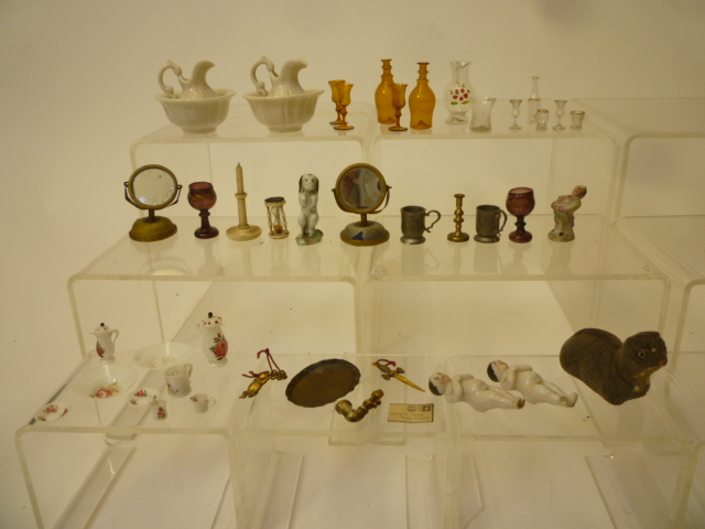 A collection of dolls house equipment comprising glass, pottery and metal table ware and other