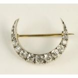 A DIAMOND CRESCENT BROOCH, set with eighteen mixed cut stones, the largest old brilliant cut stone