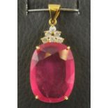 A RUBY PENDANT, the oval facet cut stone of approximately 30cts claw set below six small brilliant