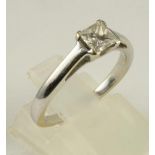 A DIAMOND SOLITAIRE RING, the princess cut stone of 0.53cts claw set to a plain unmarked white metal