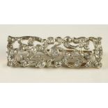 AN EDWARDIAN STYLE DIAMOND PLAQUE BROOCH of open scrolling foliate oblong form, pave set with