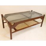 A DANISH HARDWOOD COFFEE TABLE of oblong form with rounded oblong smoke glass top on shaped and
