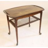A DANISH ROSEWOOD TROLLEY TABLE, the removable rounded oblong tray top pierced with loop handles,