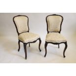 A PAIR OF VICTORIAN CARVED ROSEWOOD SIDE CHAIRS upholstered in champagne damask, the channelled