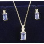 A TANZANITE AND DIAMOND SUITE, the facet cut oblong tanzanite claw set below a baguette cut