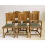 A SET OF SIX OAK DINING CHAIRS by Bob Hunter "Wren Man", the solid backs with arched crest over